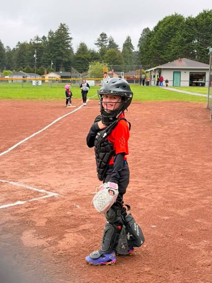 Baseball player sliding into base as another player attempts to catch the ball.