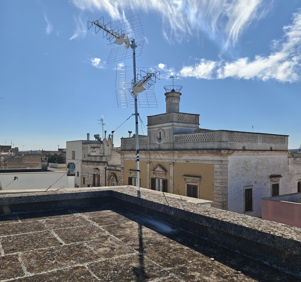 Casa con tetto di tegole rosse e pannelli solari sotto un cielo azzurro