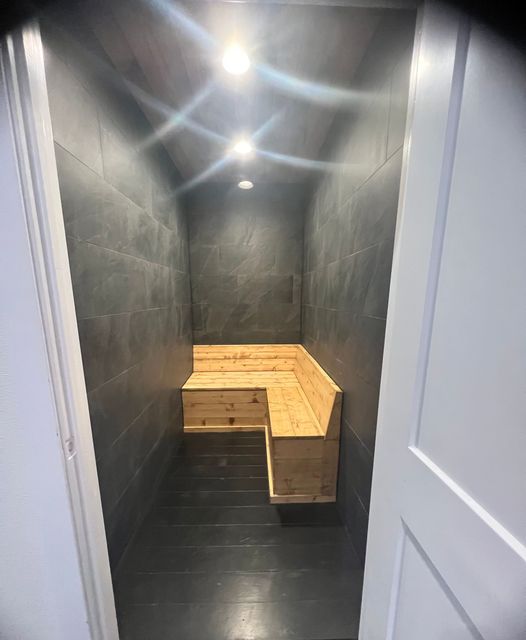 A small room with a wooden bench in the corner.