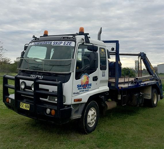A White And Blue Tow Truck Is Parked In A Grassy Field — Tamworth Skip Eze In Taminda, NSW