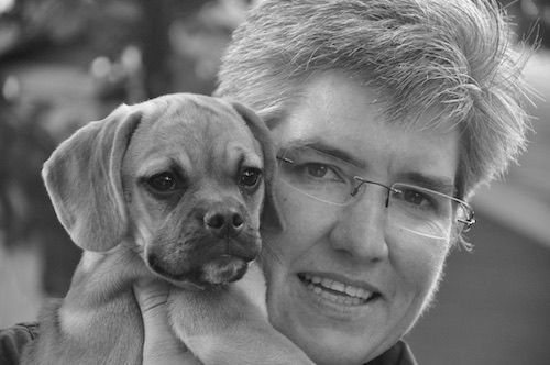 sabra tieperman with small puppy held up by her face