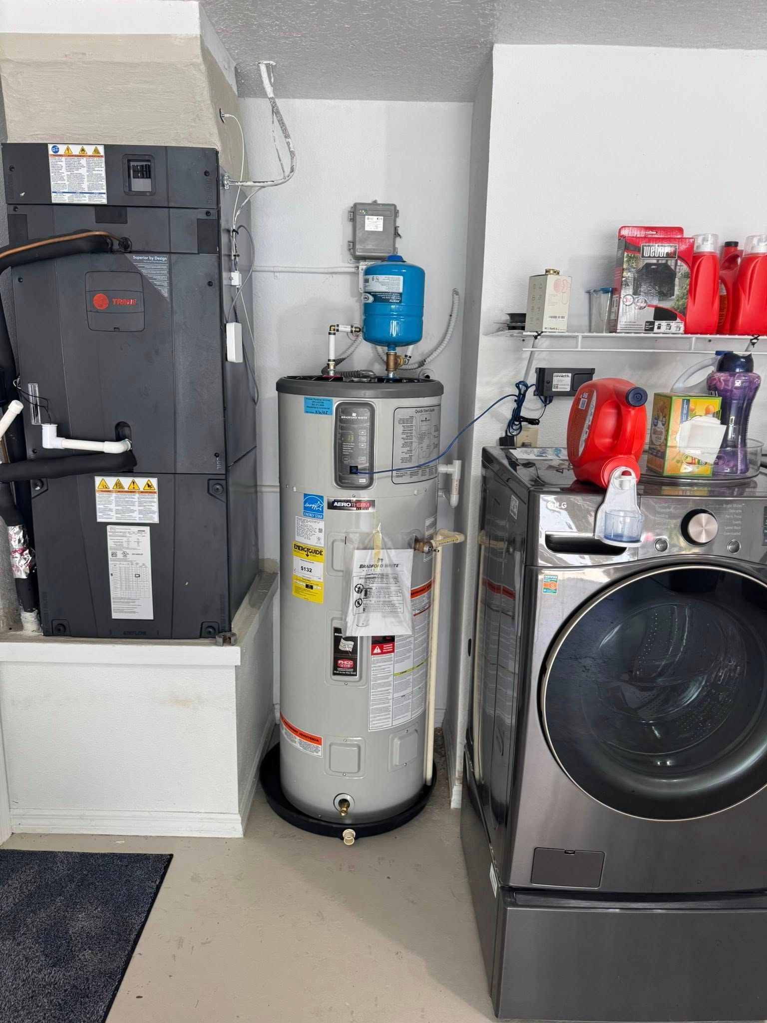 Utility room with water heater, furnace, washer, and shelves of household items