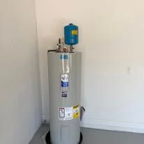 Water heater tank with a blue expansion tank in a plain utility room