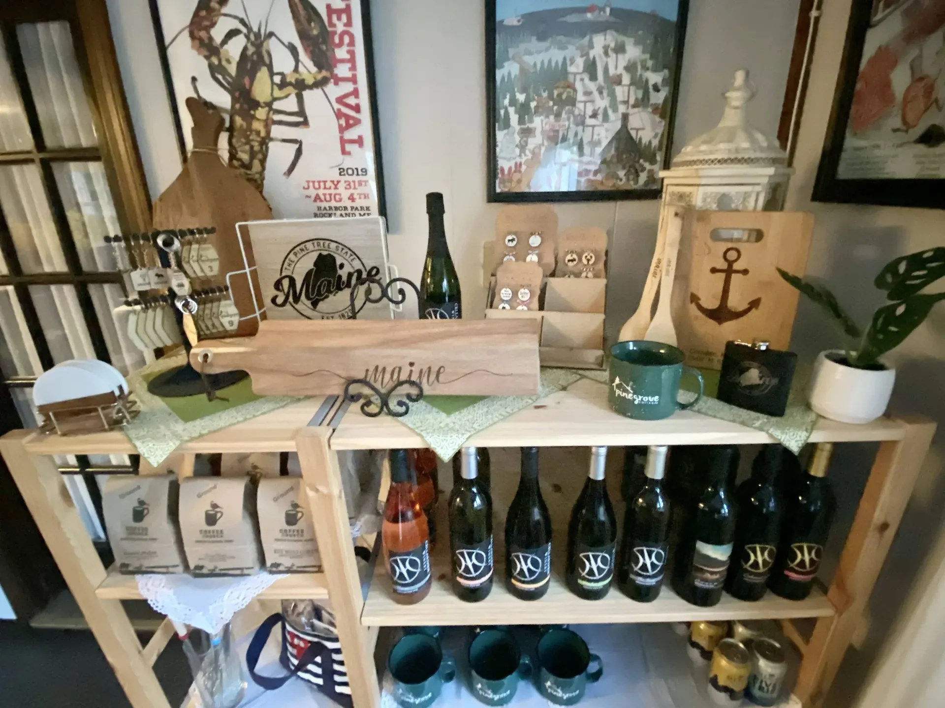 A shelf with bottles of wine and mugs on it