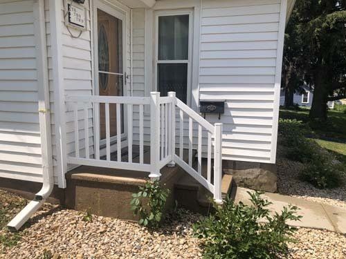Vinyl exterior of front porch and siding cleaned with soft washing techniques in Deforest Wisconsin