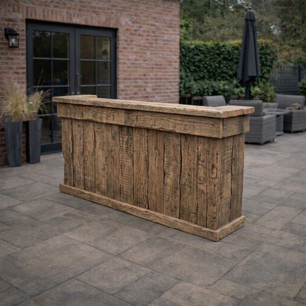 Rustieke houten bar op een terras naast een bakstenen muur en een zithoek buiten.