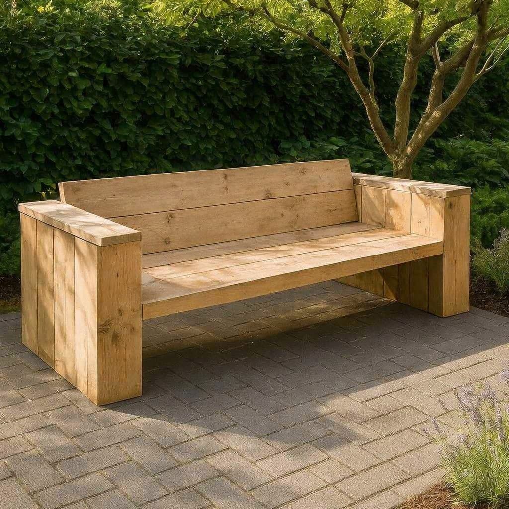 Houten bank op een betegeld terras naast een heg en een boom.