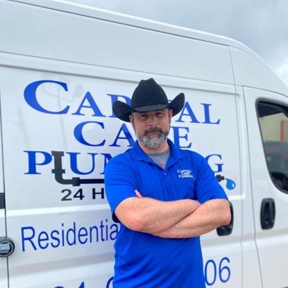 A man in a cowboy hat stands in front of a van that says canal care plumbing