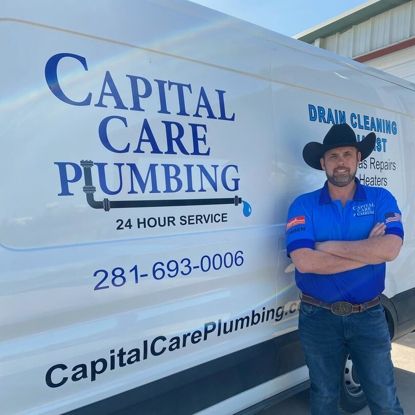A man in a cowboy hat is standing in front of a van that says capital care plumbing