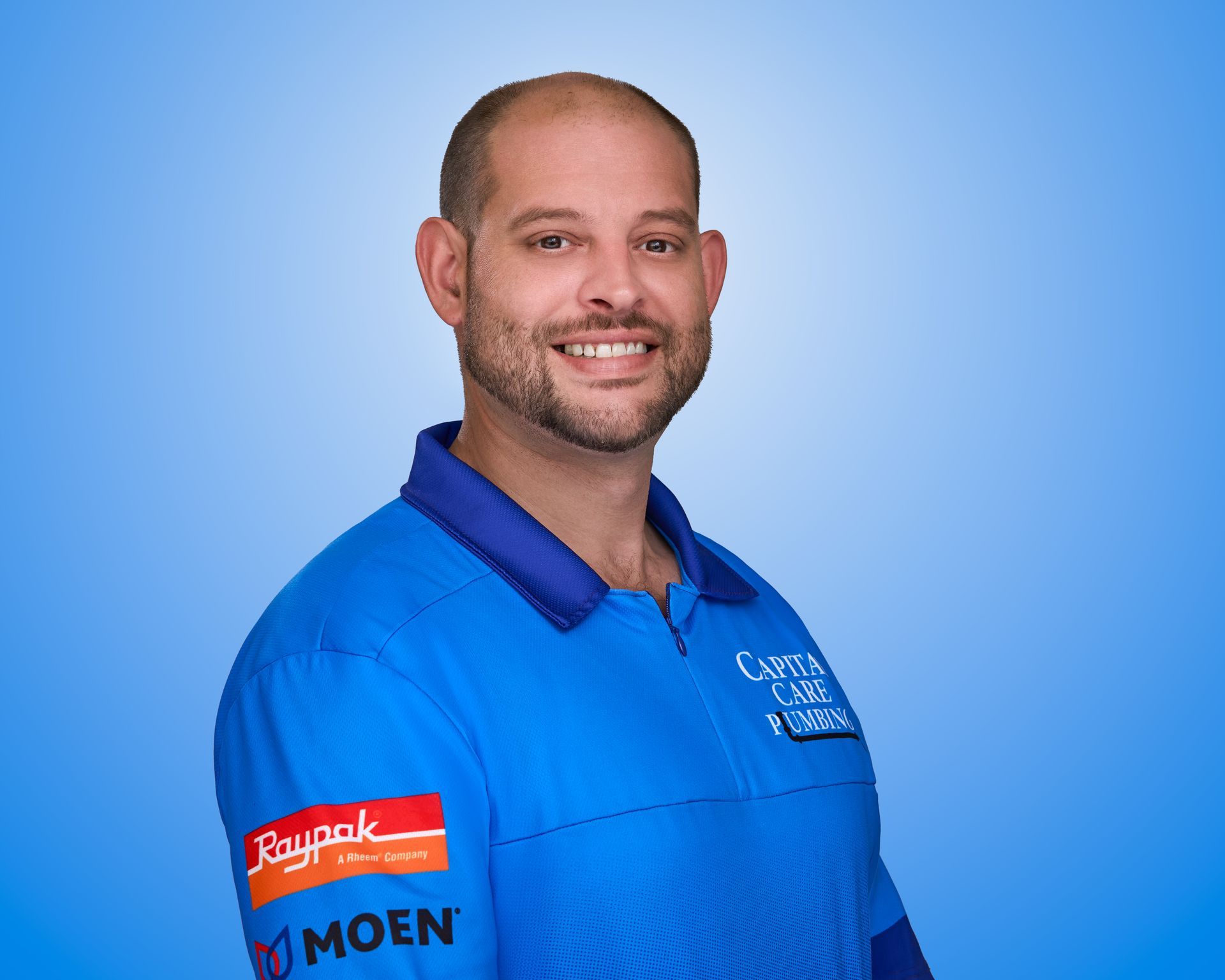 A man in a blue shirt is smiling for the camera.