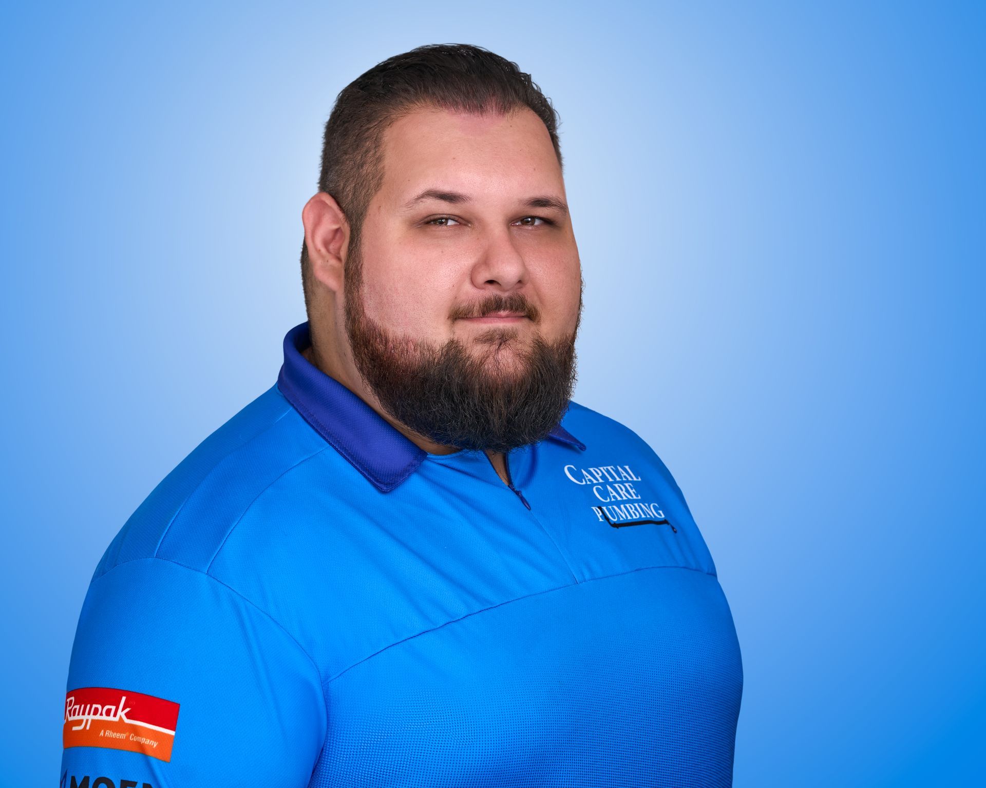 A man with a beard is wearing a blue shirt.