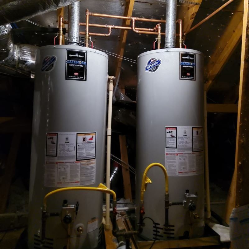 Two water heaters are sitting in a dark room