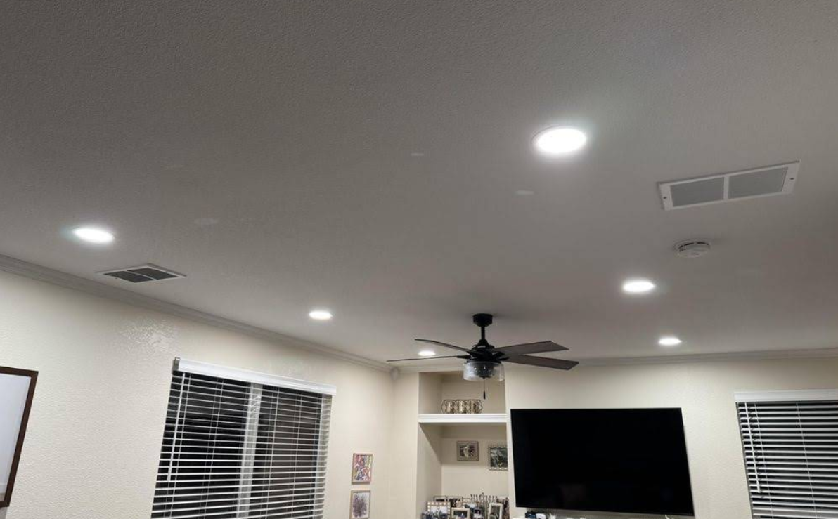 Living room ceiling with recessed lights, ceiling fan, TV, windows with blinds, and wall decor