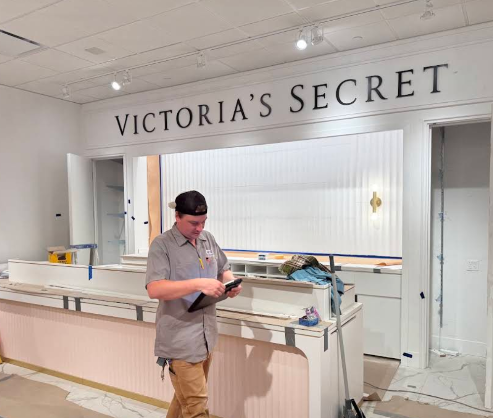 Inside a Victoriaβs Secret store, a person stands at the counter in a mostly empty retail space.