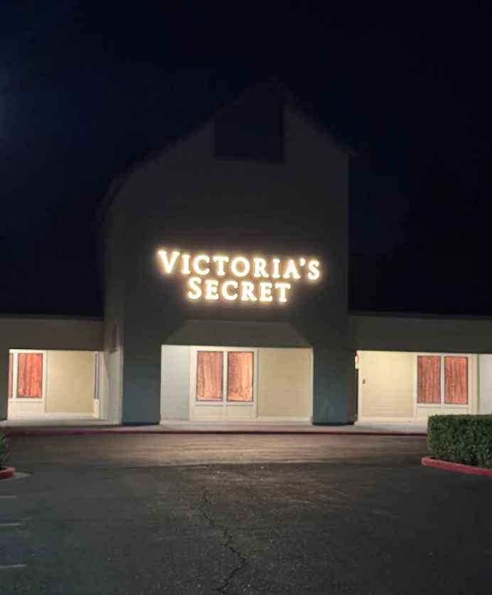 Victoriaβs Secret storefront at night, lit sign above a dark parking lot