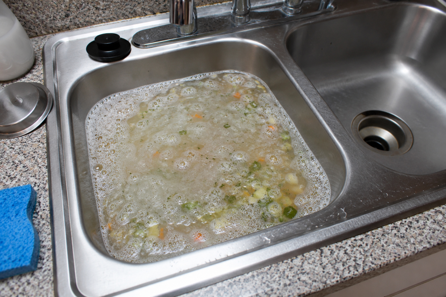 Dirty dishwater and food scraps in a stainless steel kitchen sink. Dirty dishwater and food scraps in a stainless steel kitchen sink.