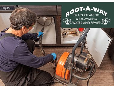 Plumber using a drain-cleaning machine on a kitchen sink