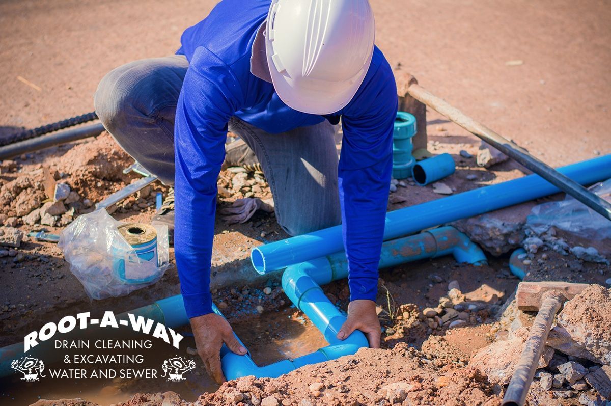Worker fixing the blue pipes on a construction site