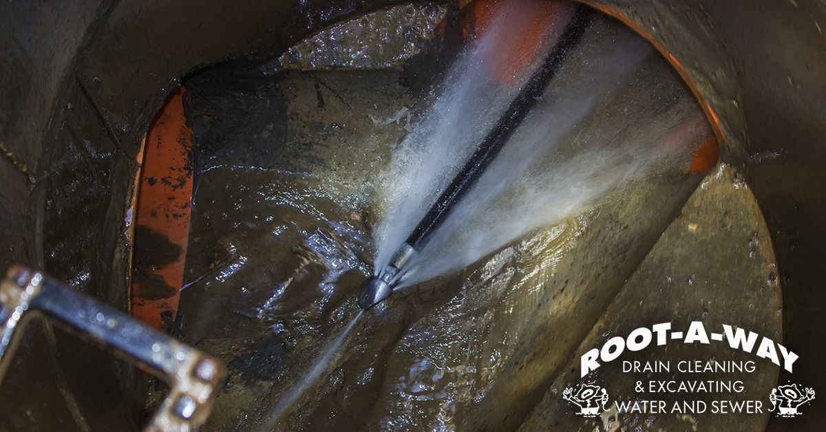 Close-up of a dark, wet pipe interior with a drain-cleaning tool Close-up of a dark, wet pipe interior with a drain-cleaning tool