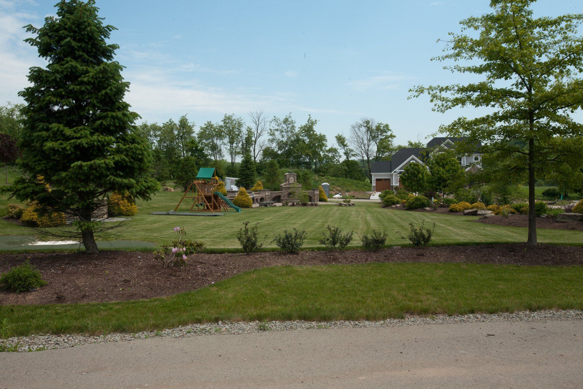 A lush green yard with a house in the background