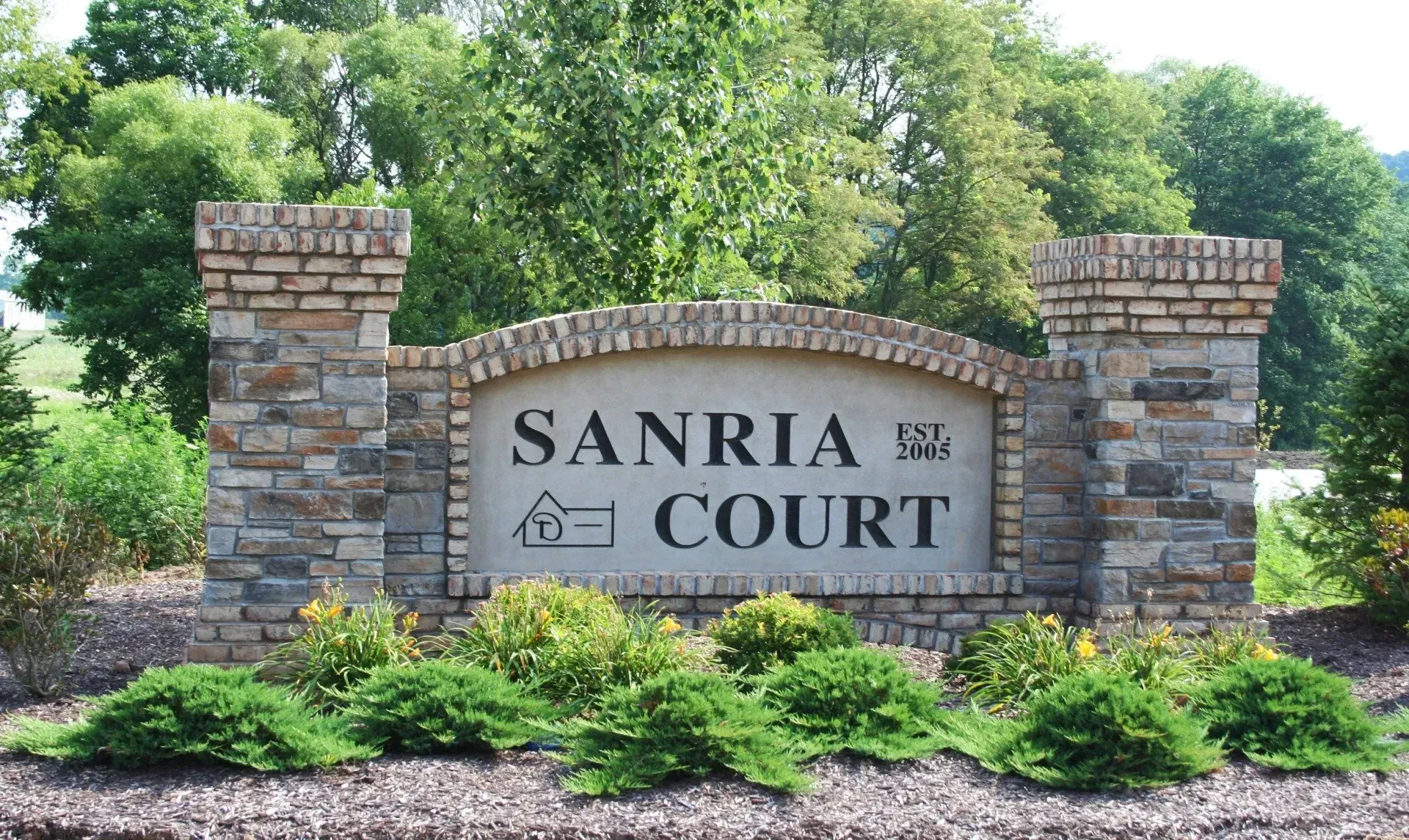 A stone sign that says sanria court on it