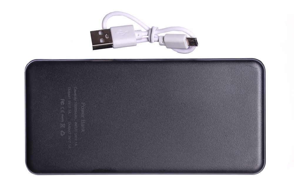 Czarny power bank z dołączonym do niego białym kablem
