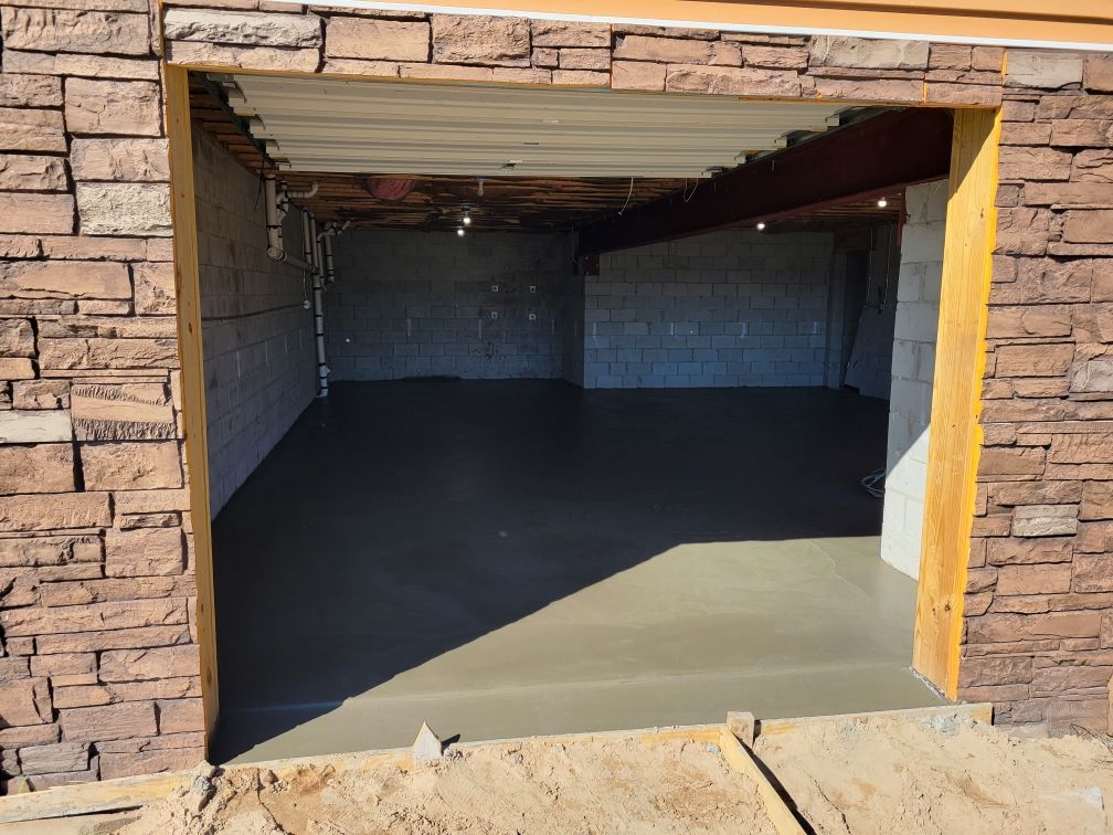 Open garage interior with concrete floor and stone exterior framing the entrance