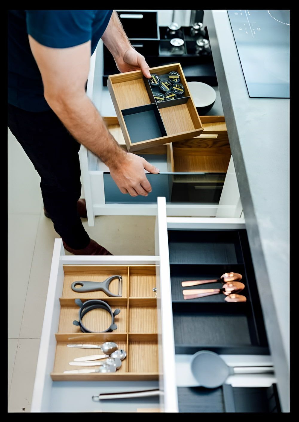 A Man Is Taking A Cutlery Tray Out Of A Kitchen Drawer — Wood Cabinet Hardware Distributors In Bungalow, QLD