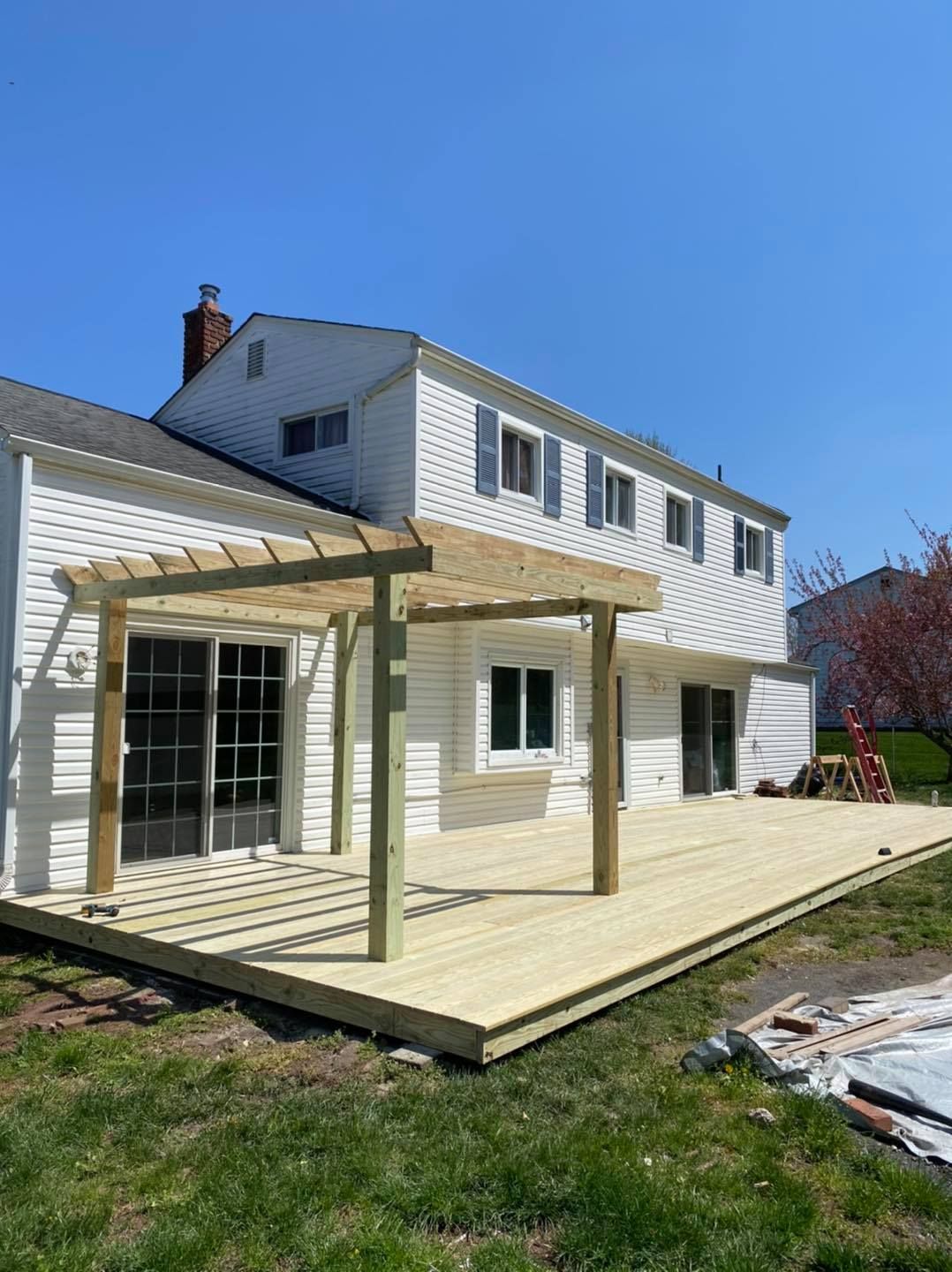 A large white house with a wooden deck in front of it.