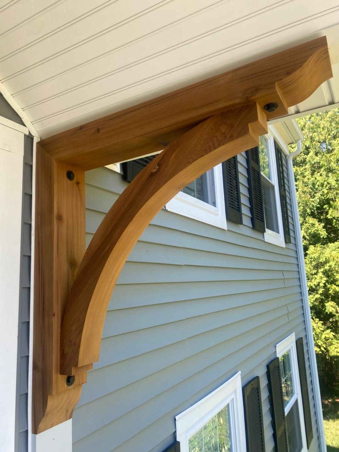 A wooden bracket is attached to the side of a house