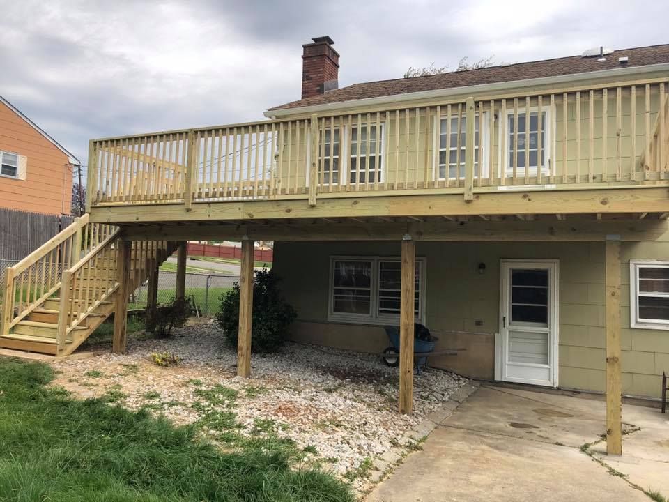 The back of a house with a wooden deck and stairs.