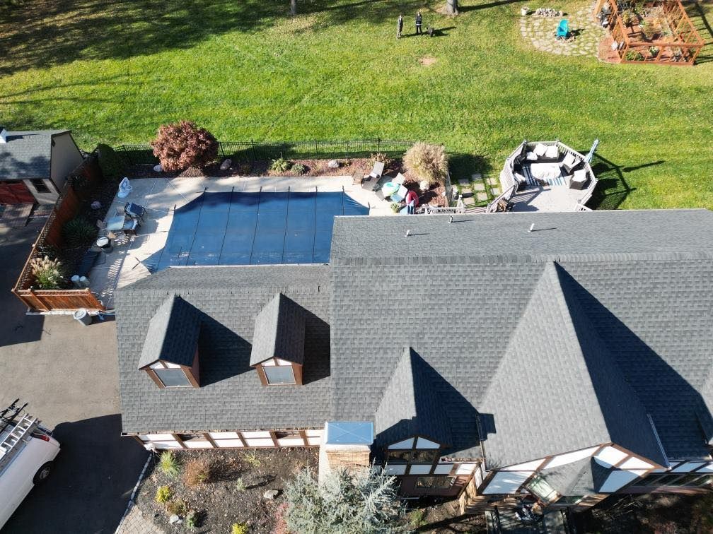 An aerial view of a house with a large pool in the backyard.