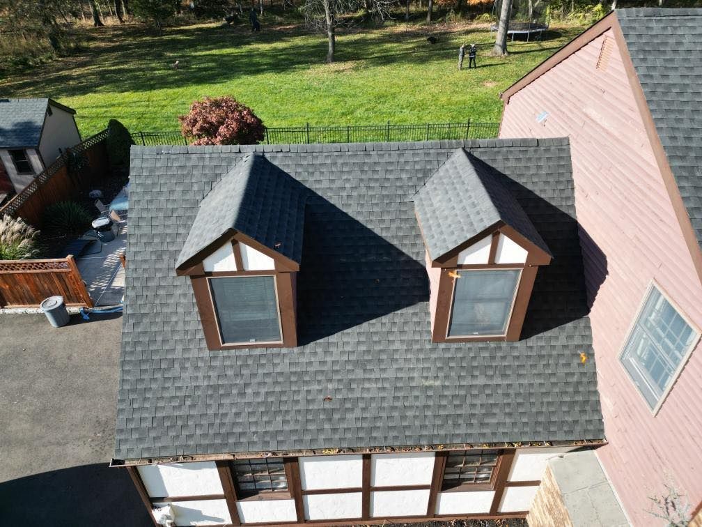 An aerial view of a house with two windows on the roof.