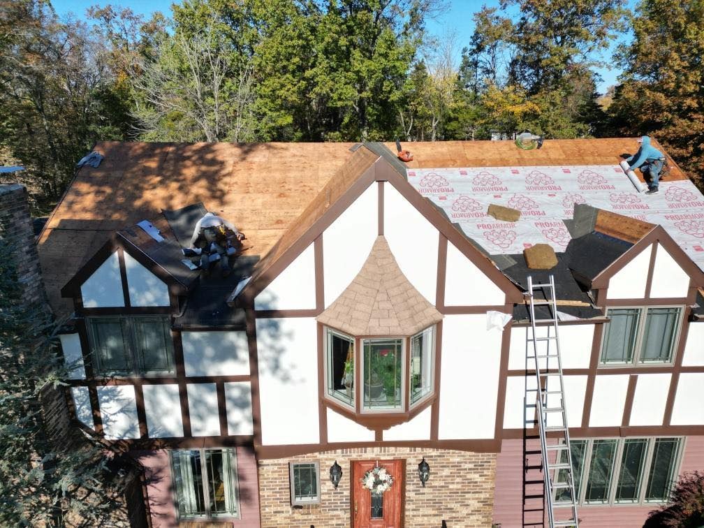 A roofer is working on the roof of a house.