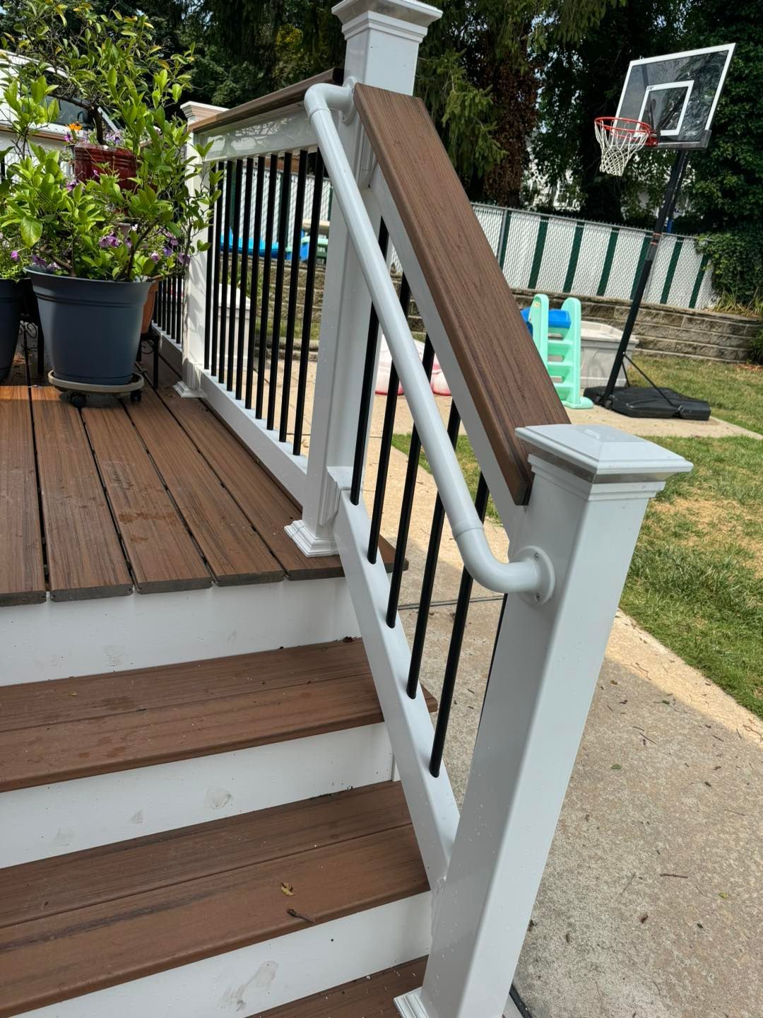 A deck with stairs and a basketball hoop in the background.
