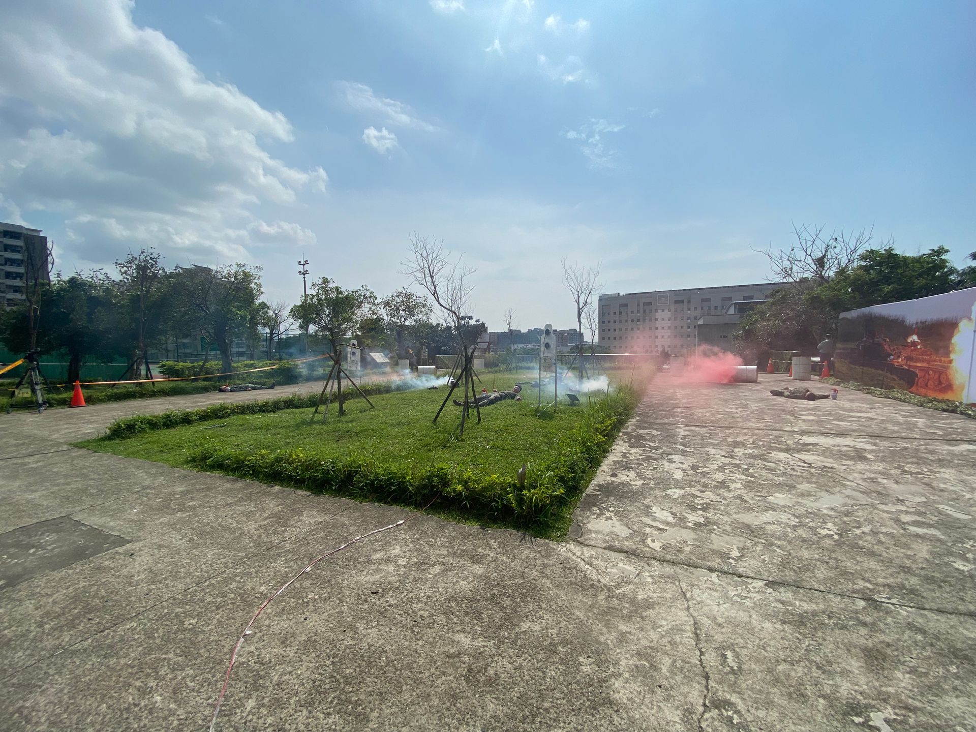 煙霧瀰漫在藍天下綠草如茵的公園、鋪砌的小路和建築物中。