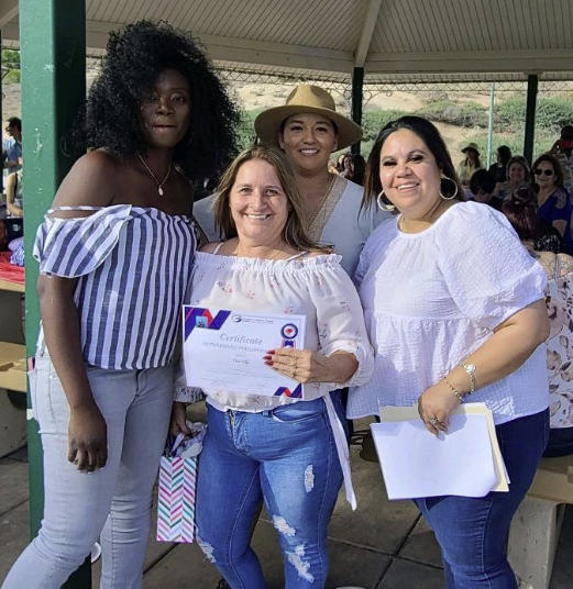 caregiver walking next to elder patient in a wheelchair