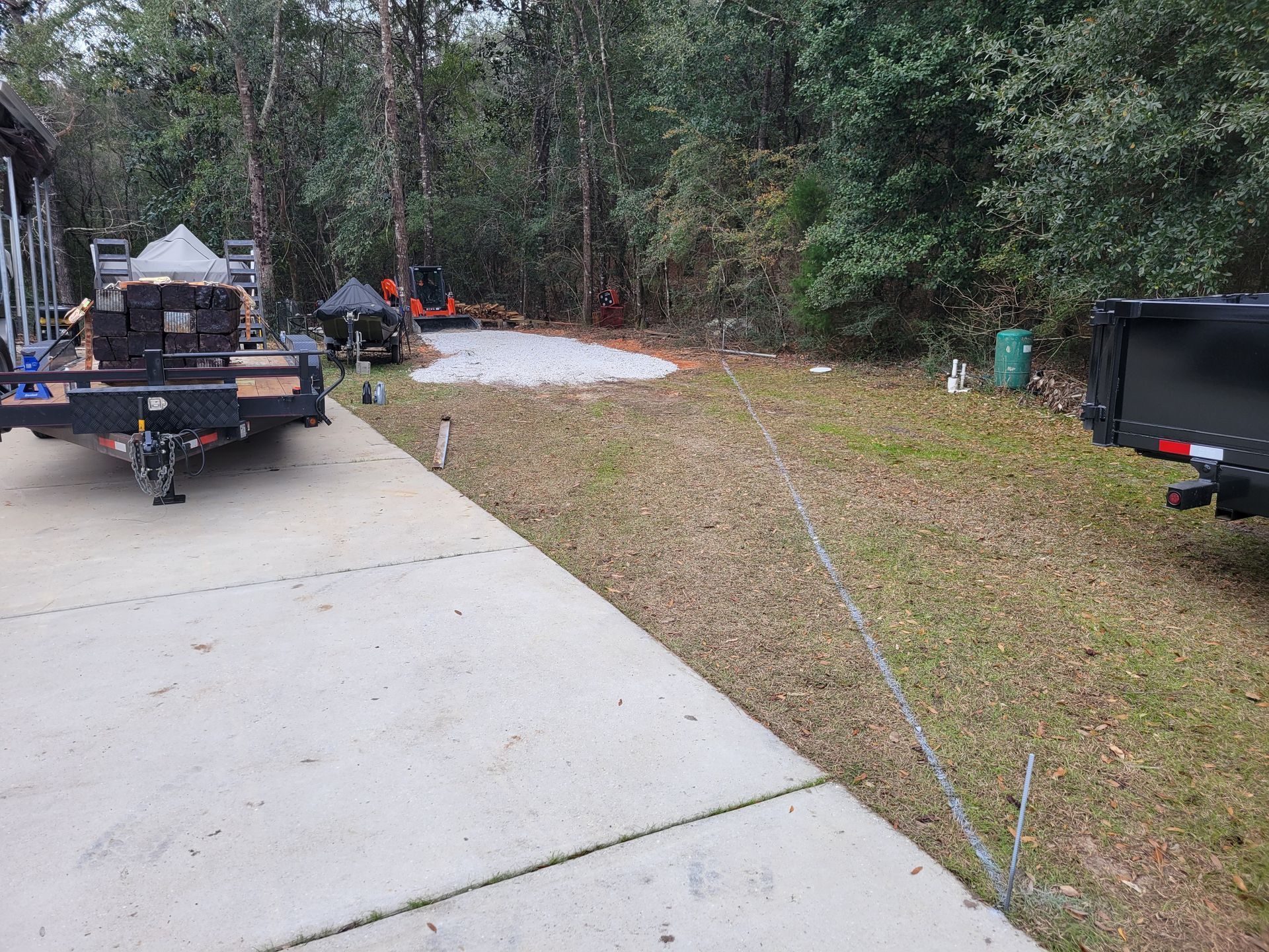 A trailer is parked on the side of the road next to a house.