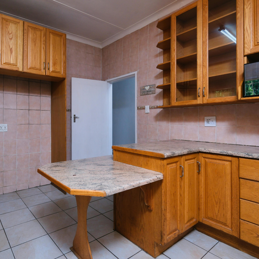 Kitchen with blue cabinets, open doors, stainless steel appliances, and wood-look flooring.