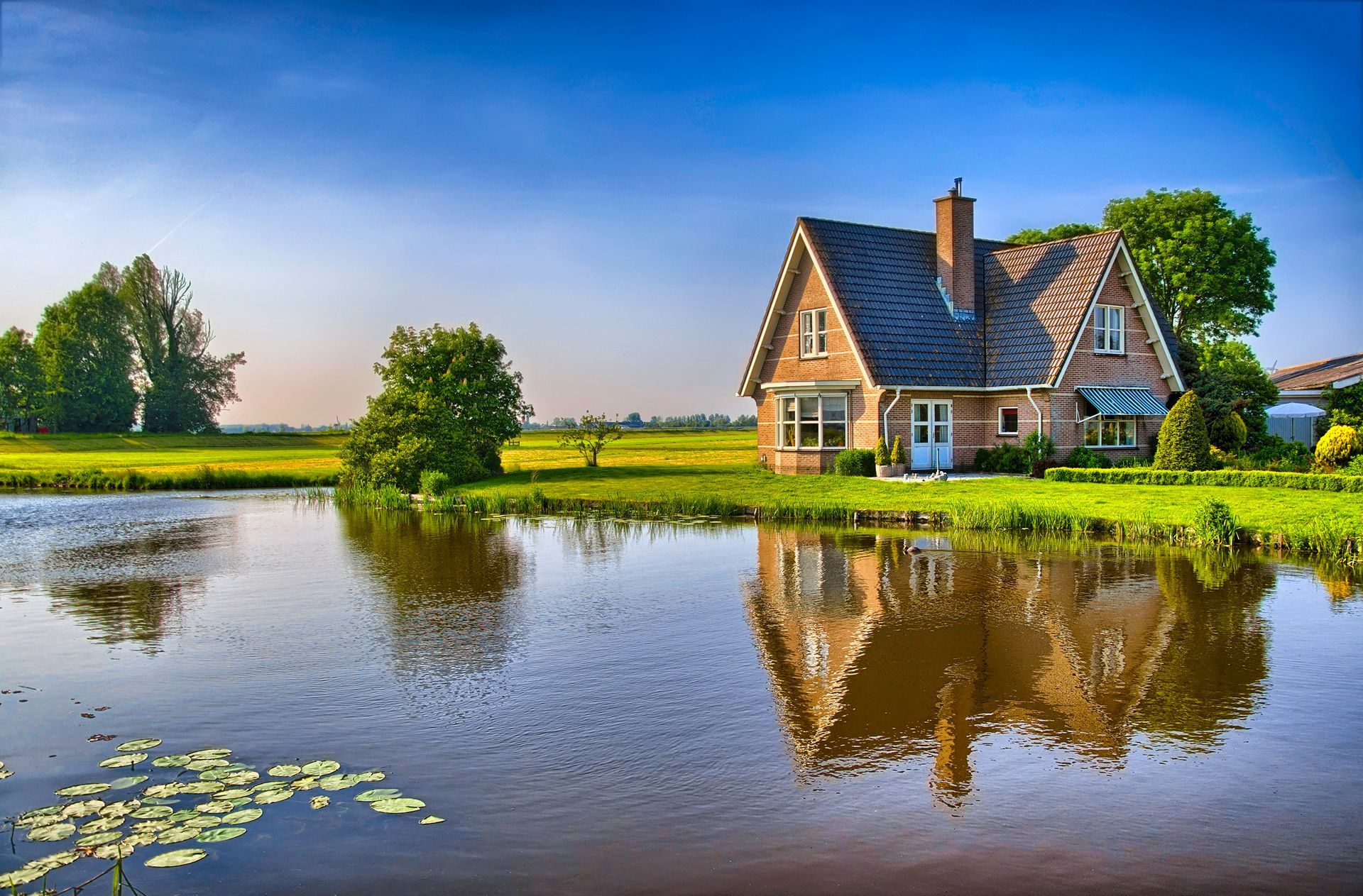 A house is reflected in the water of a pond