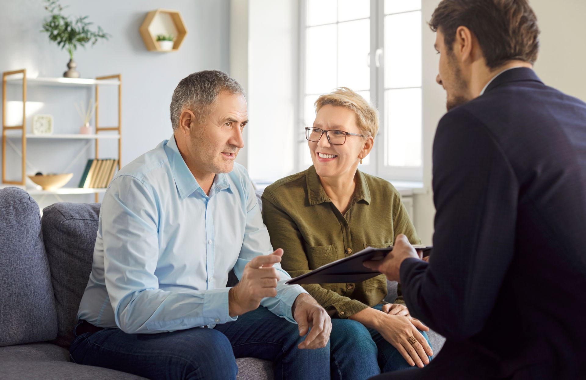 Couple consulting with a lawyer on estate planning in a professional setting.