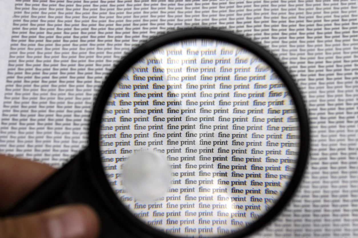 Magnifying glass over a page of tiny text that reads