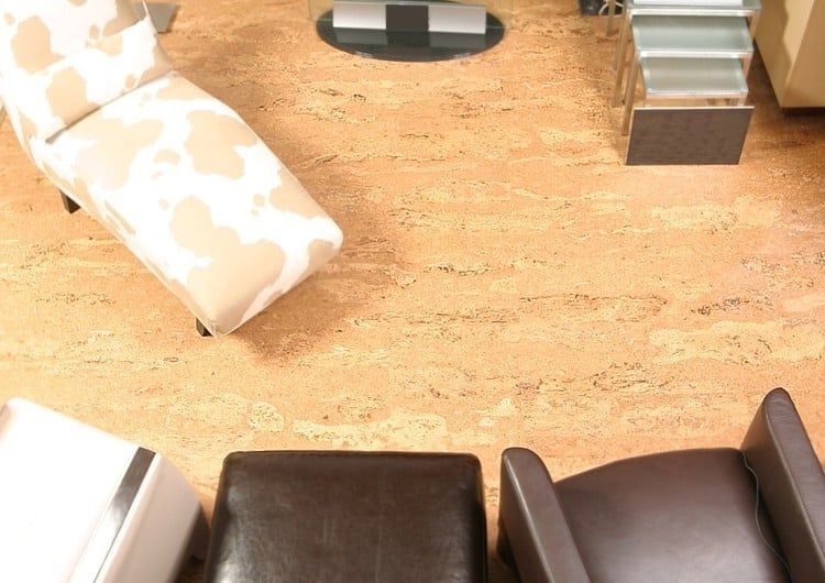 Un salon avec chaises et poufs sur un sol en liège