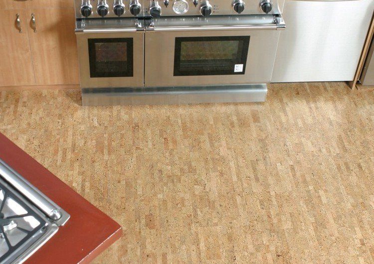 Cuisine au sol en liège clair devant une cuisinière en inox.