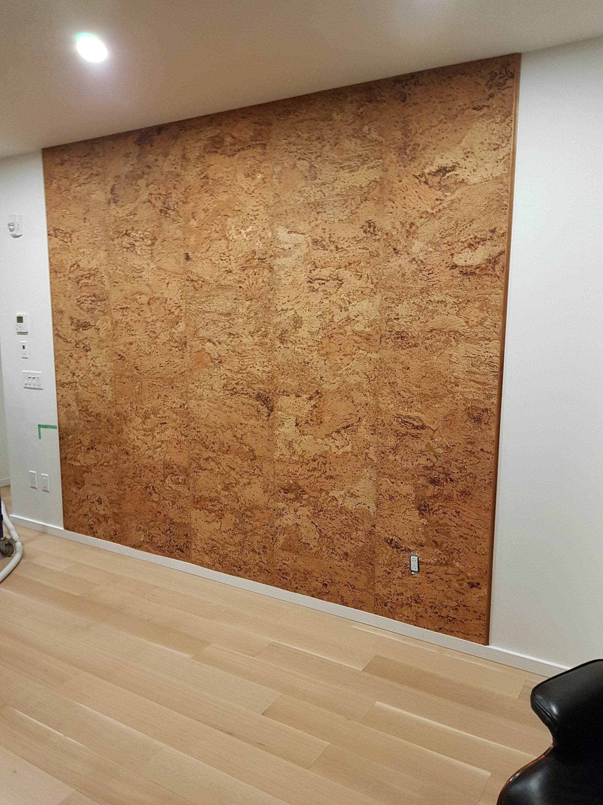 Un mur en liège est en cours d'installation dans un salon.