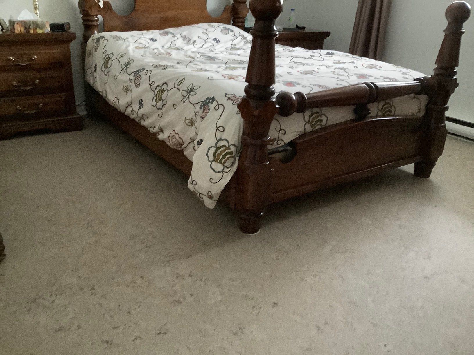 Une chambre avec un lit en bois et une table de nuit