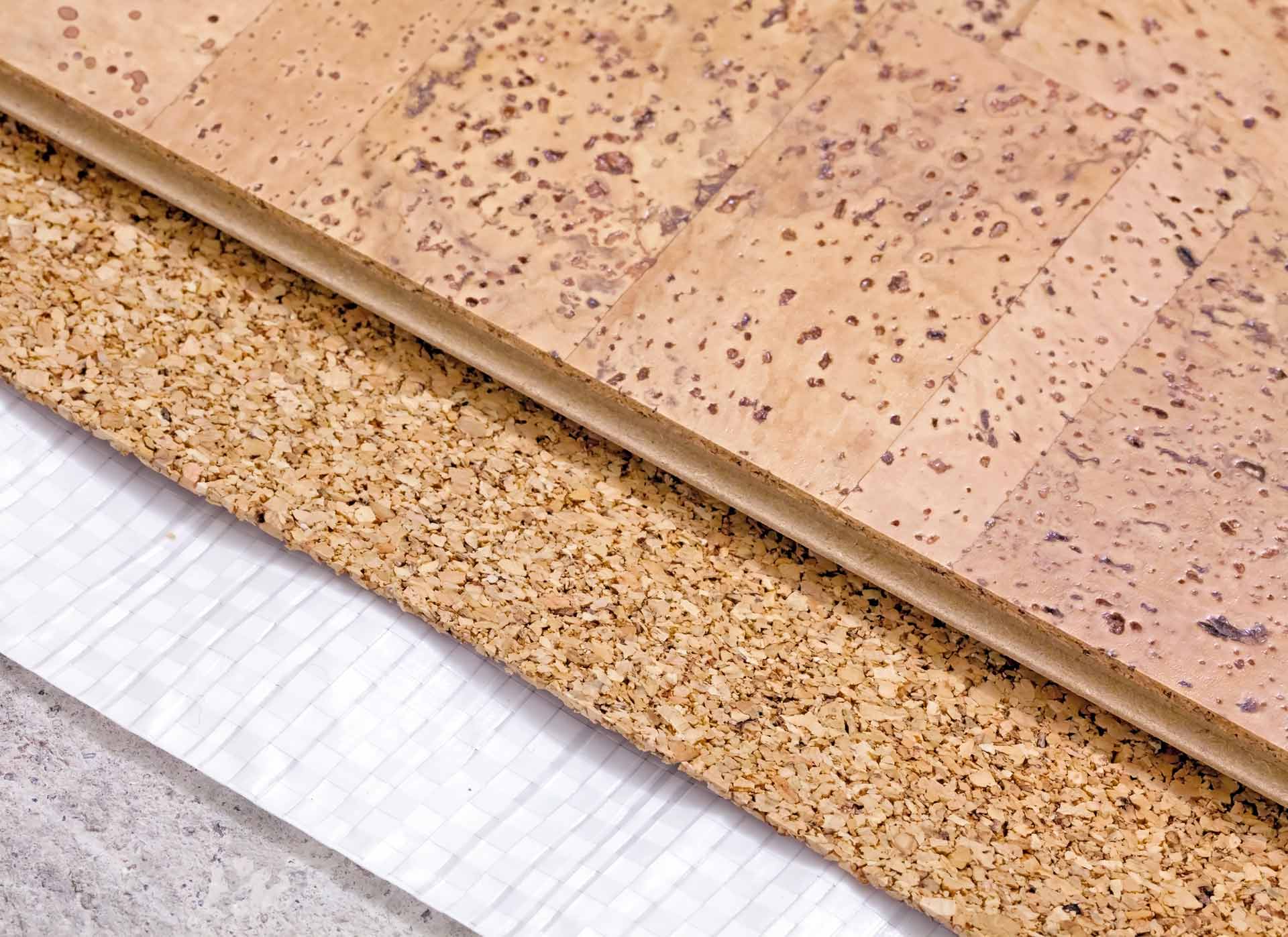 Coupe transversale d'un revêtement de sol en liège : couche supérieure, âme en liège, sous-couche et support.