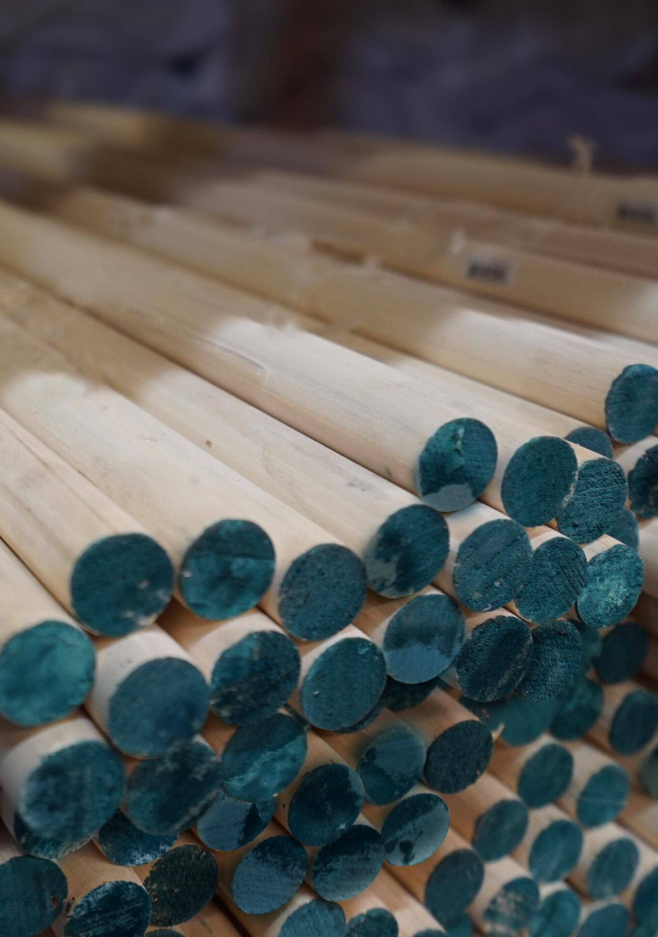 Une pile de bâtons de bois aux extrémités bleues empilés les uns sur les autres.