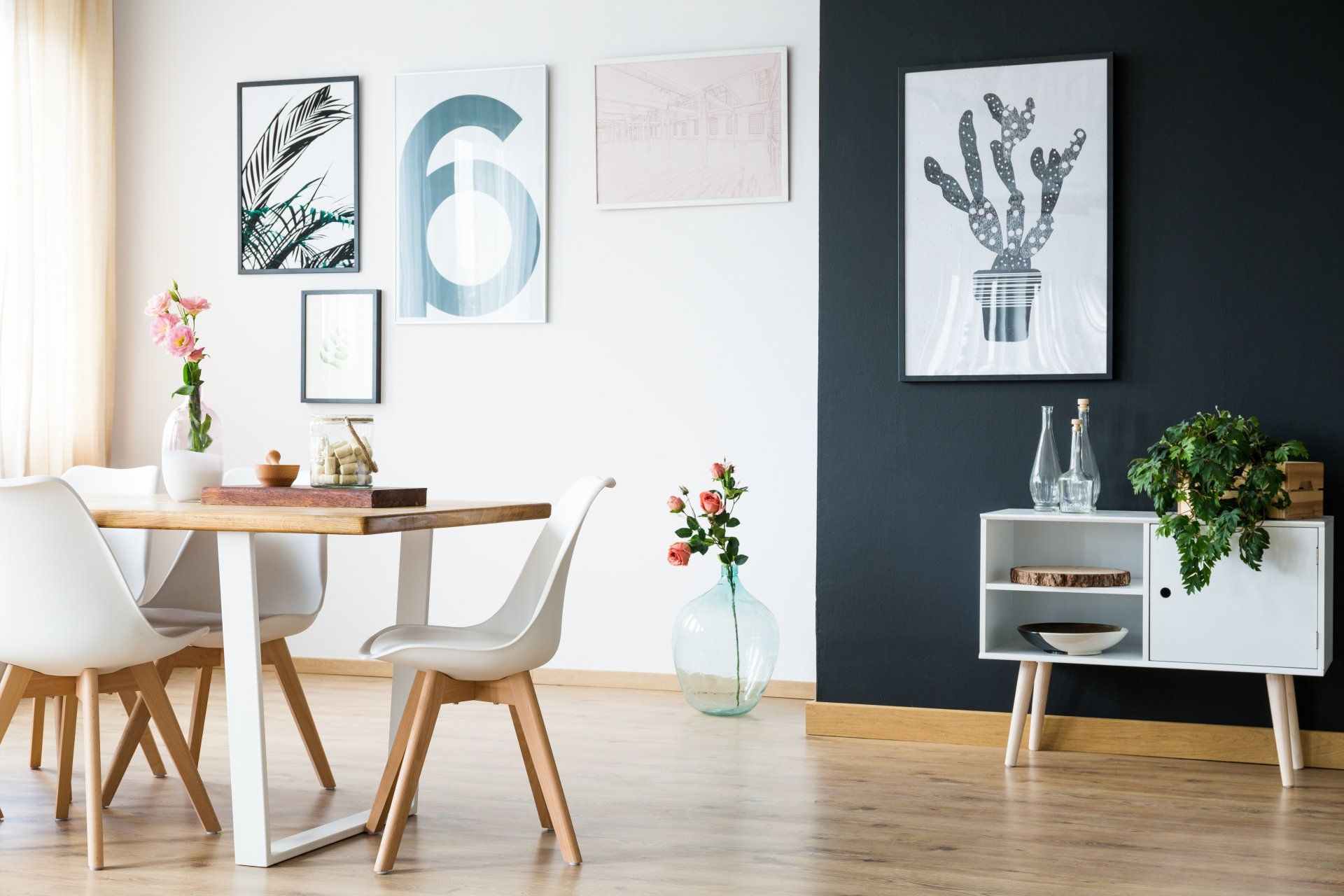 Une salle à manger avec une table et des chaises et un mur noir.