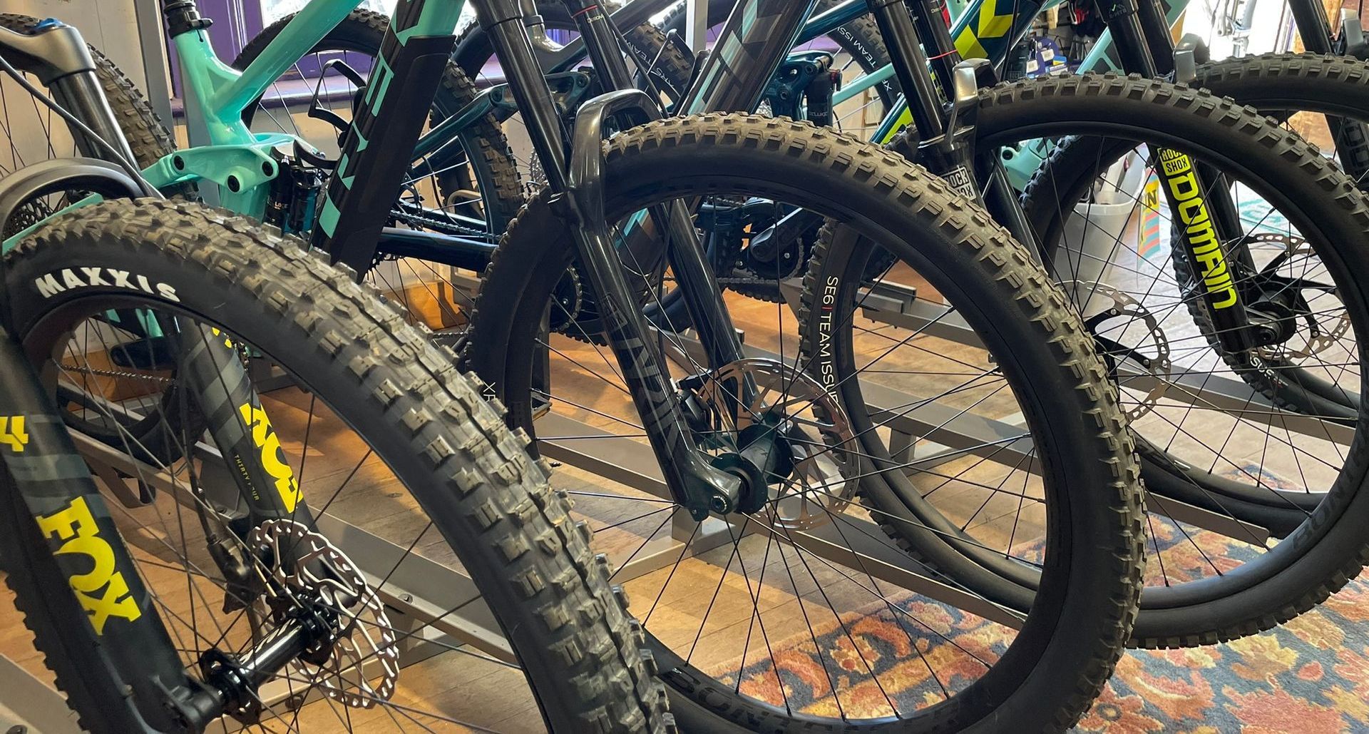 A bunch of bicycles are lined up on a table.
